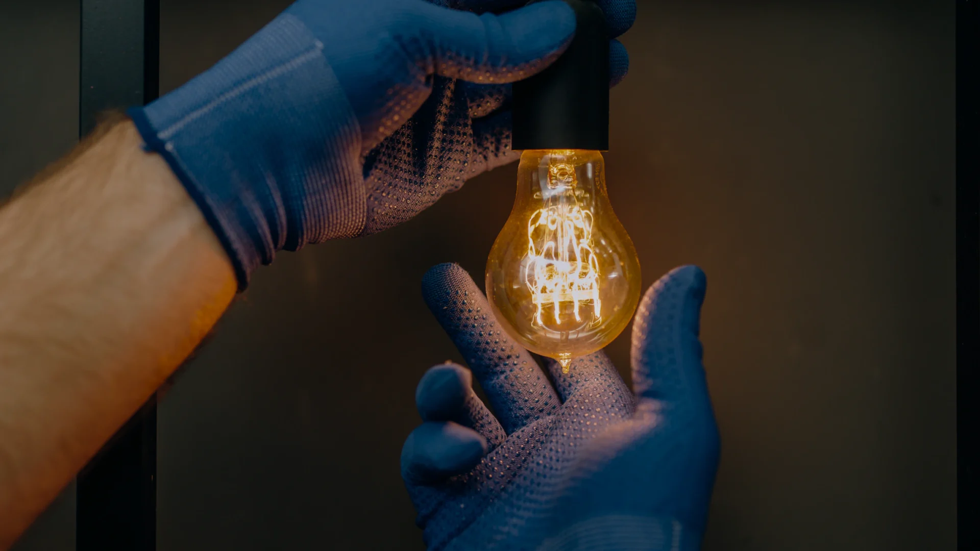man holding light bulb with gloves